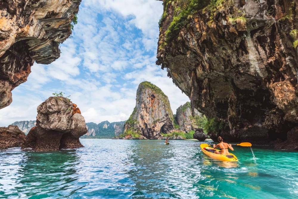 Un touriste fait du kayak sur la plage de Krabi, en Thaïlande.